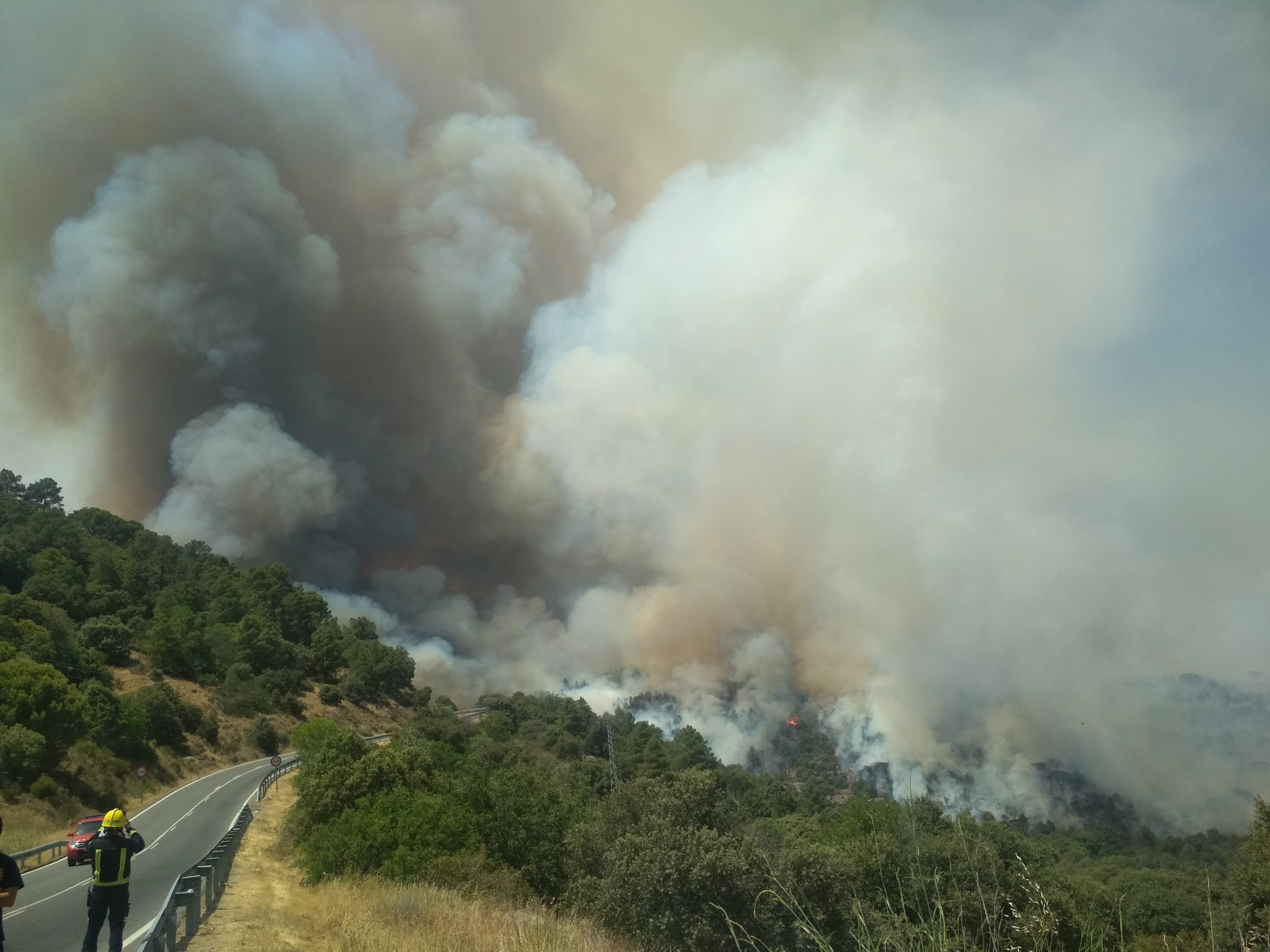 Smoke and flames from a wildfire advancing through hills near Cenicientos, in the Madrid region